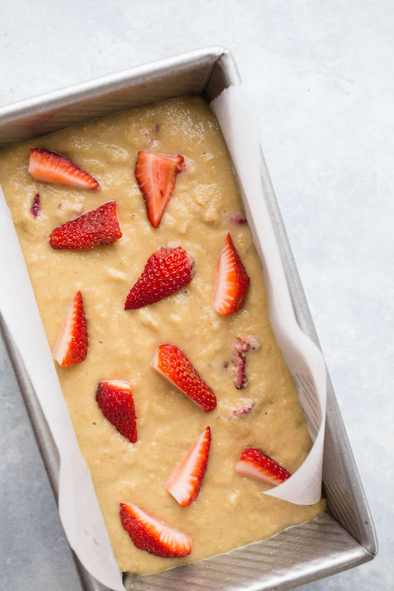 Roasted Strawberry Banana Bread made with almond flour, gluten-free oat flour, coconut sugar, ripe bananas, and topped with extra strawberries. A healthy banana bread recipe that is gluten-free, dairy-free, and refined sugar-free! 