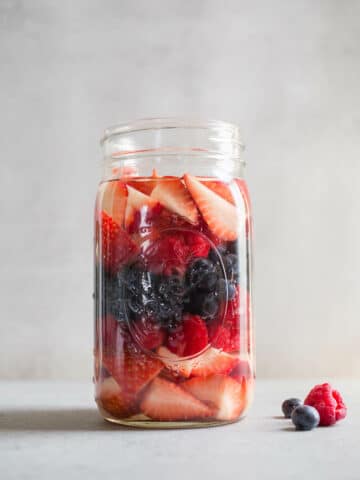 A large glass jar with berries.