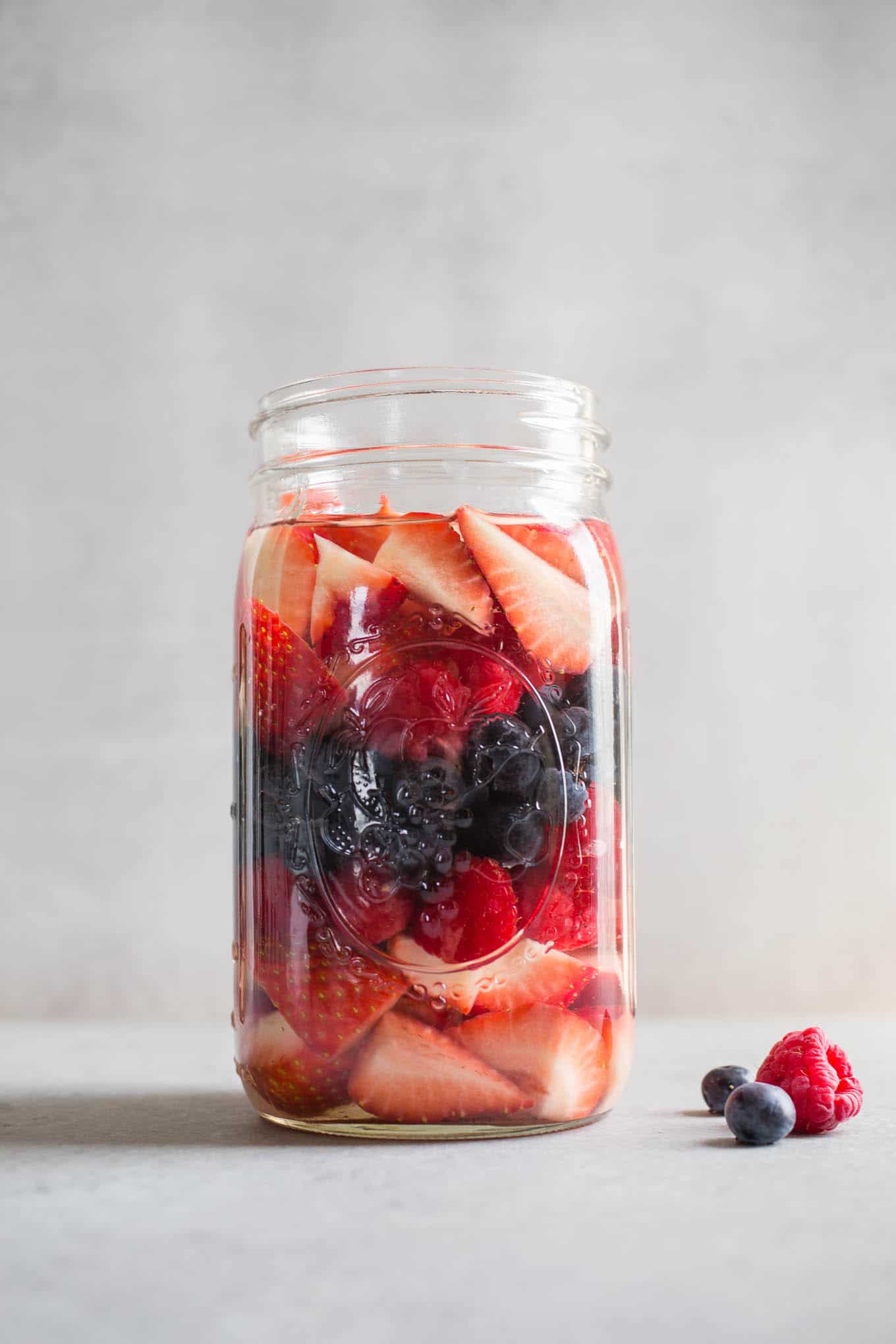 A large glass jar with berries.