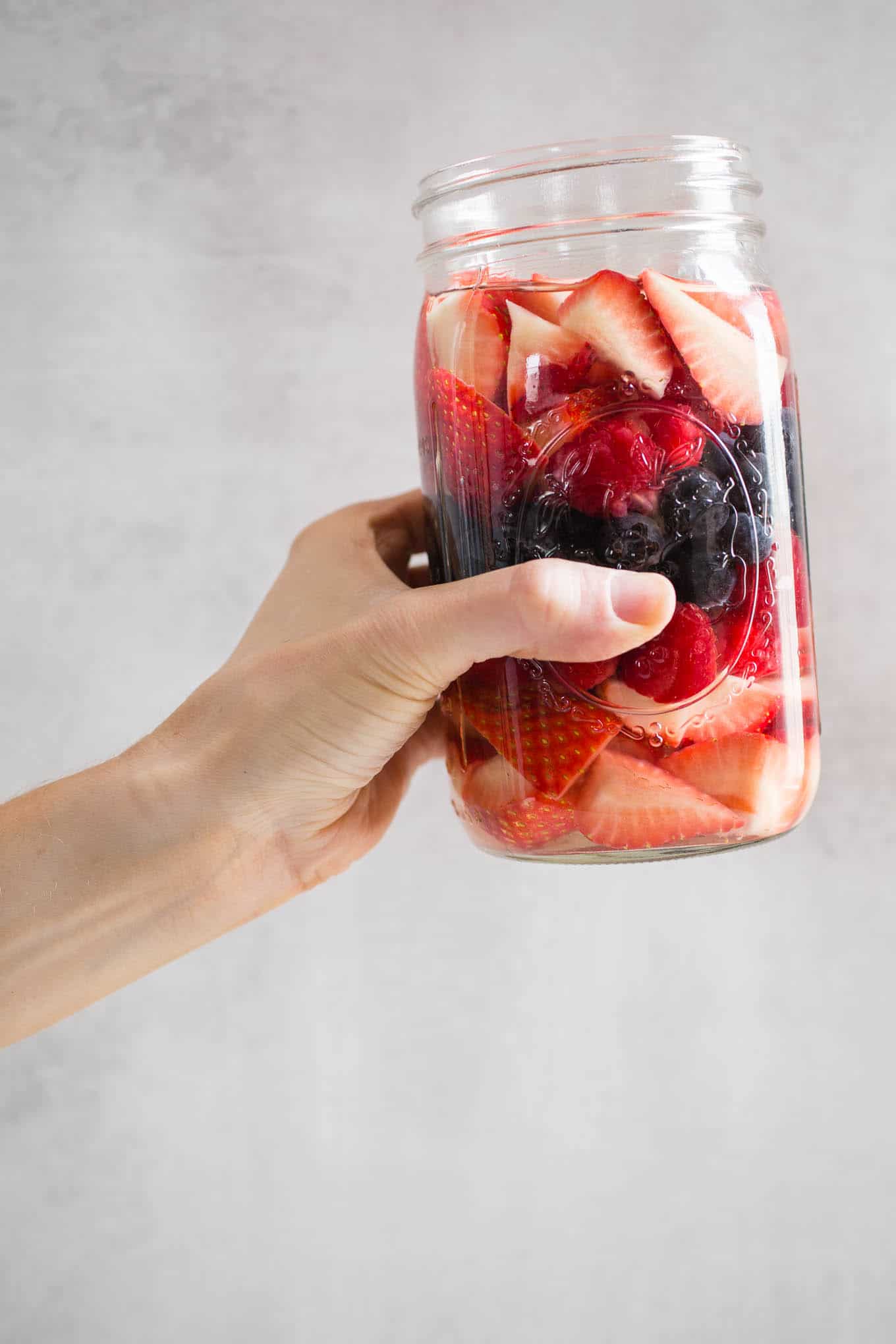 A jar of berries being held up.