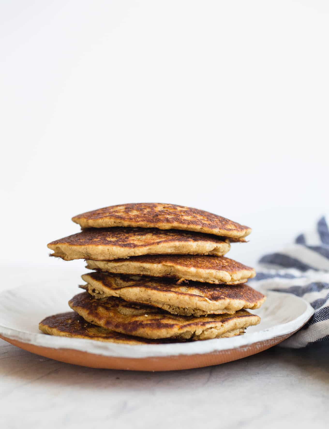 Gluten-free Vegan Oat Flour Pancakes made with whole grain gluten-free oats, white rice flour, applesauce, and non-dairy buttermilk, for a light and tender crumb. An oat flour pancake recipe made without eggs or bananas. Easy and delicious!
