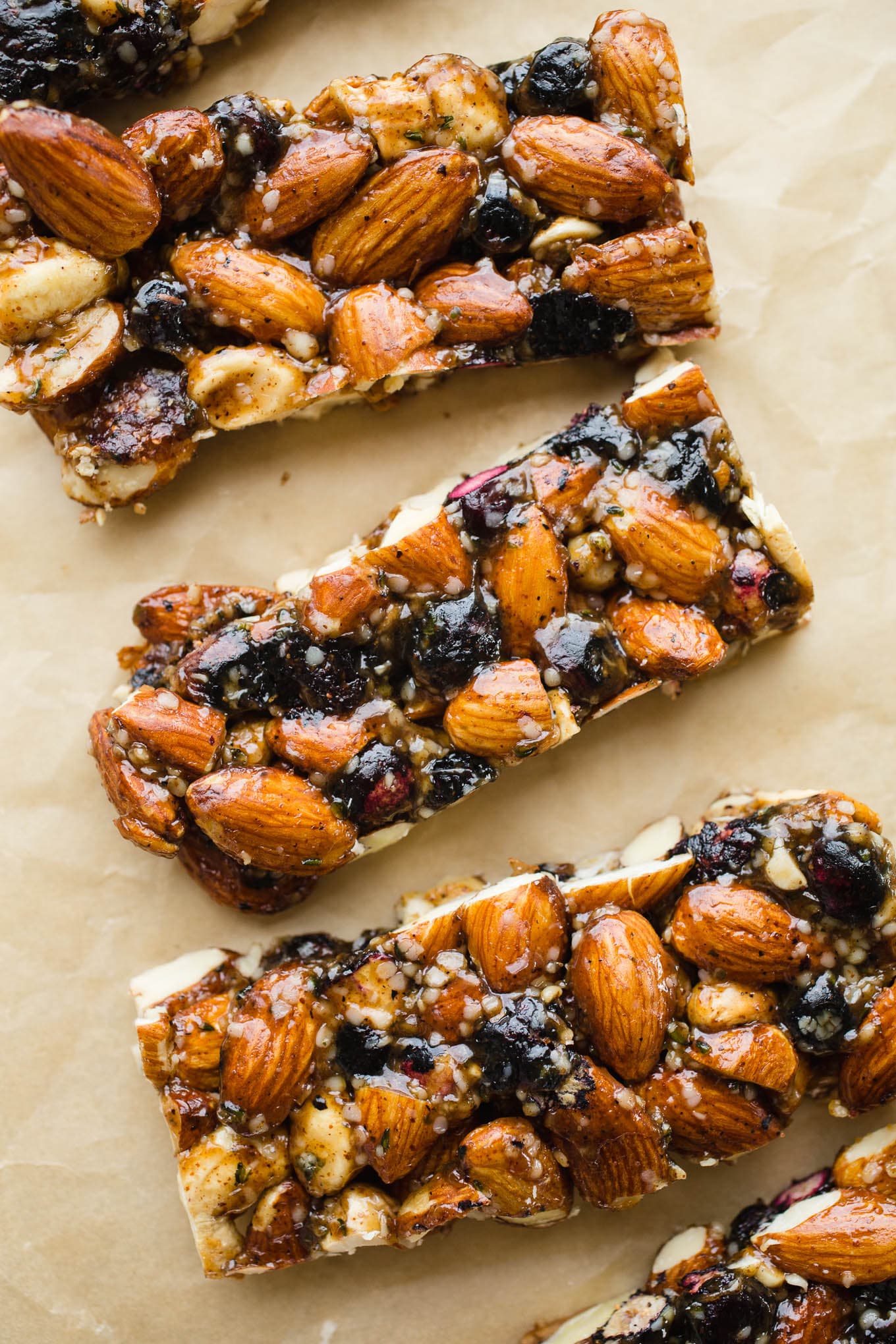 Nut and blueberry granola bars on brown parchment paper.