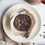 Chocolate muffin on a white plate.