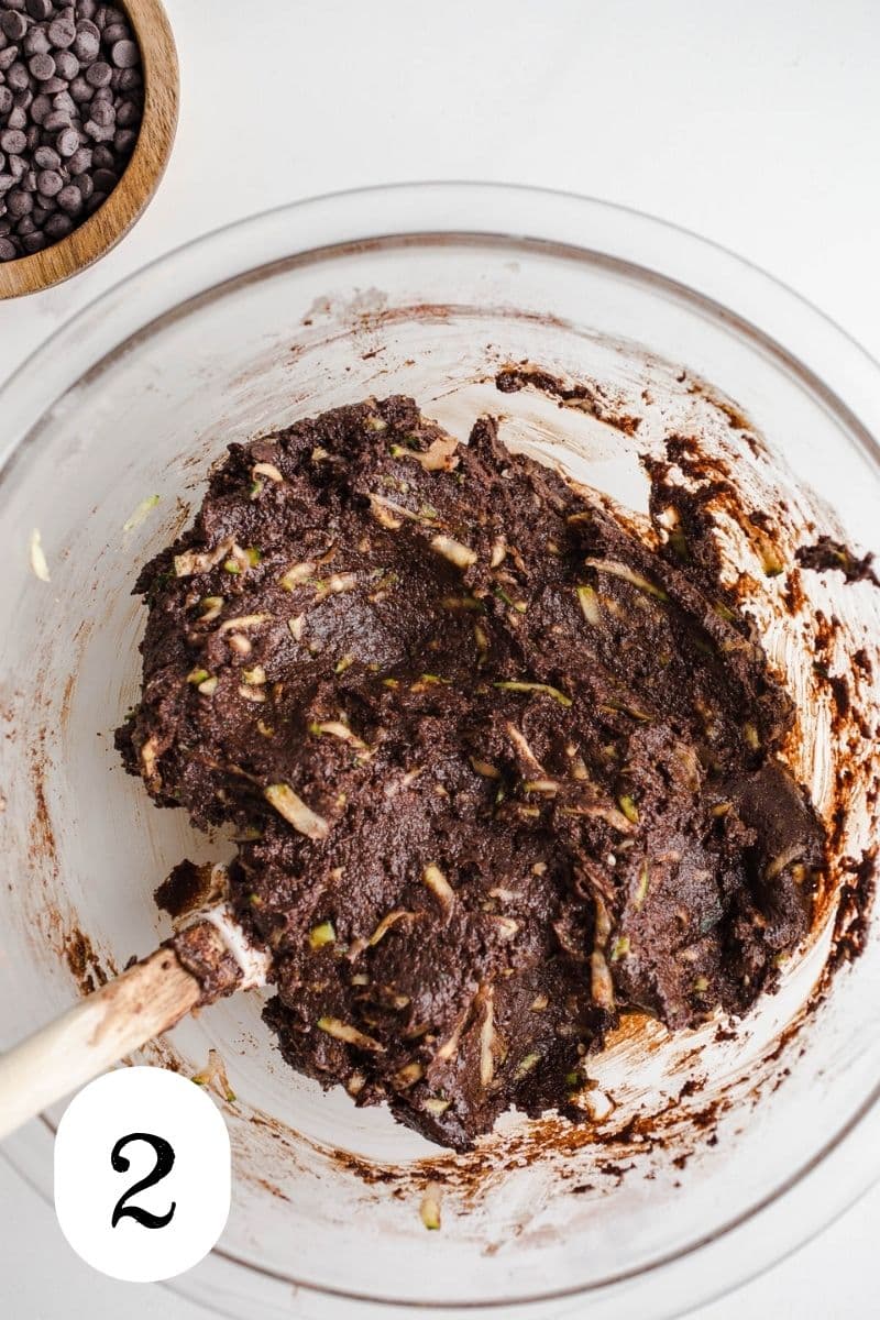 Shredded veggies in a chocolate batter in a mixing bowl.