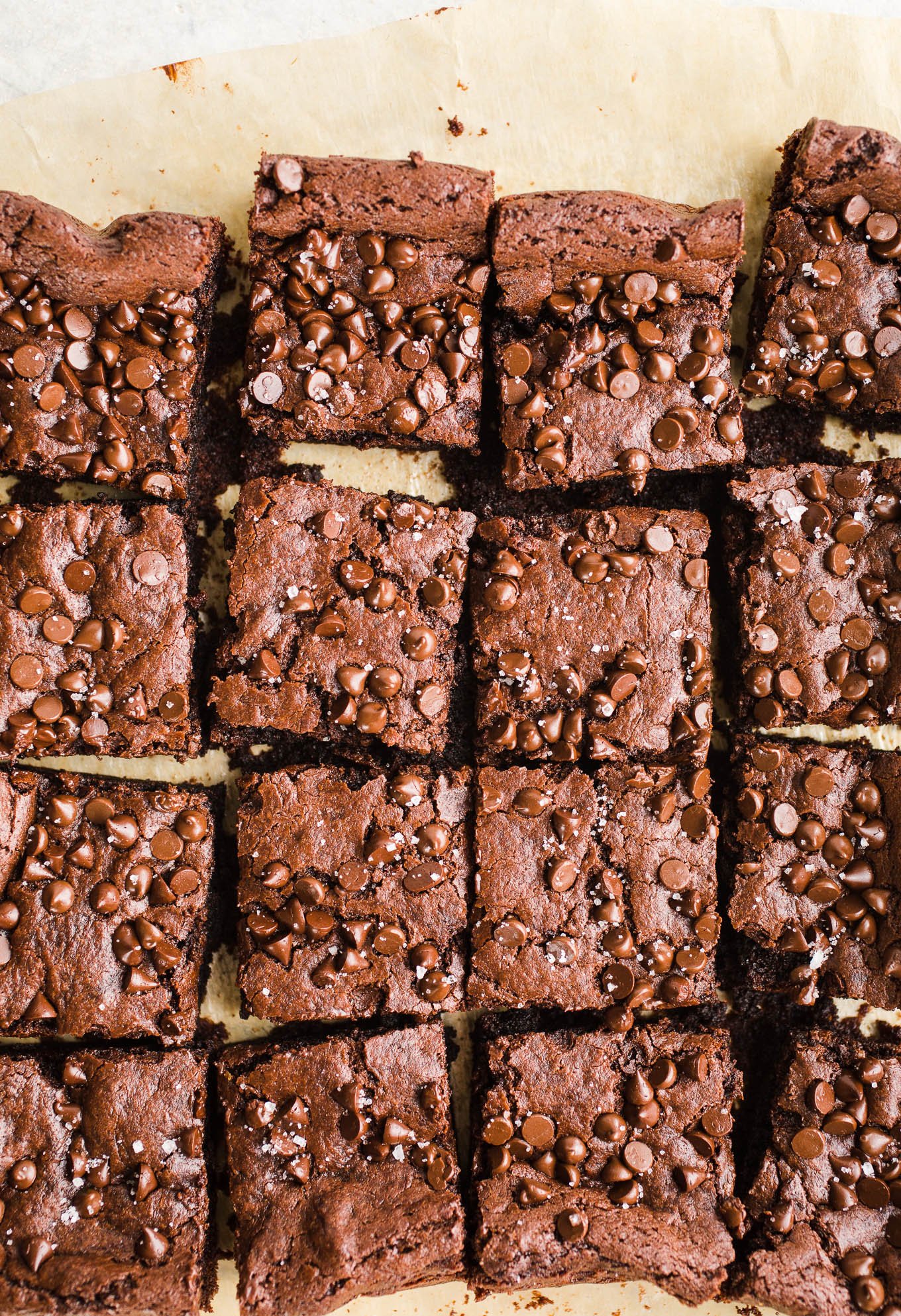 Vegan Tahini Brownies made with rich cocoa powder, tahini, maple syrup, chocolate chips, and topped with sea salt. Gluten-free. 