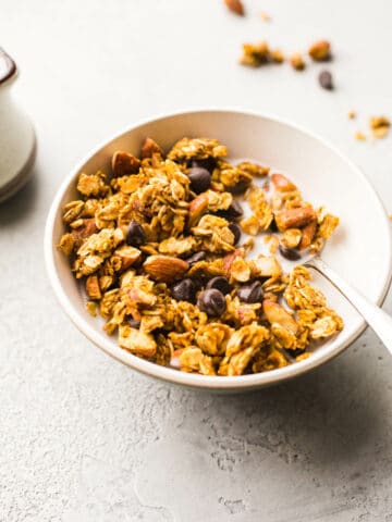 Granola with chocolate chips in a white bowl.