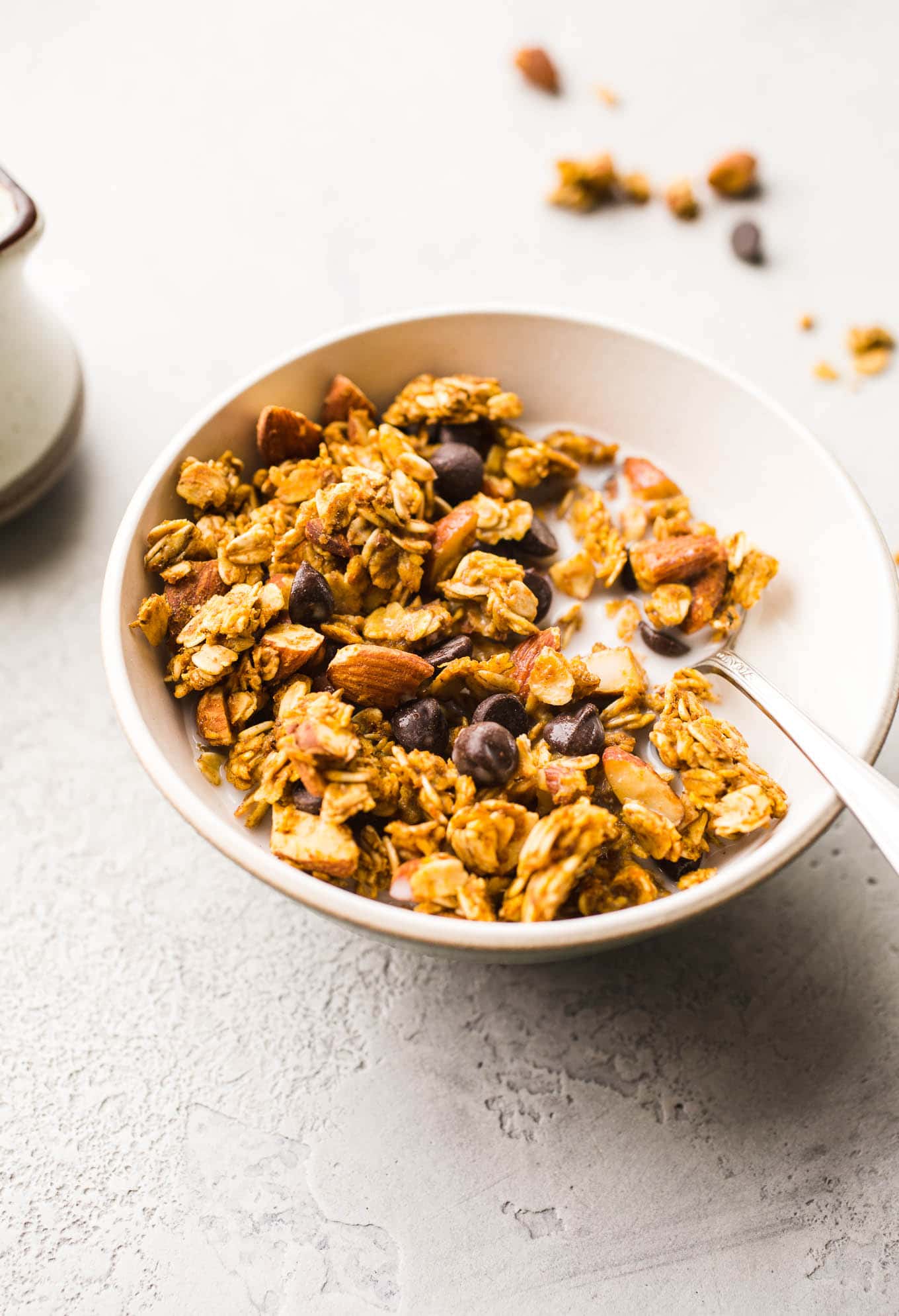 Granola with chocolate chips in a white bowl.