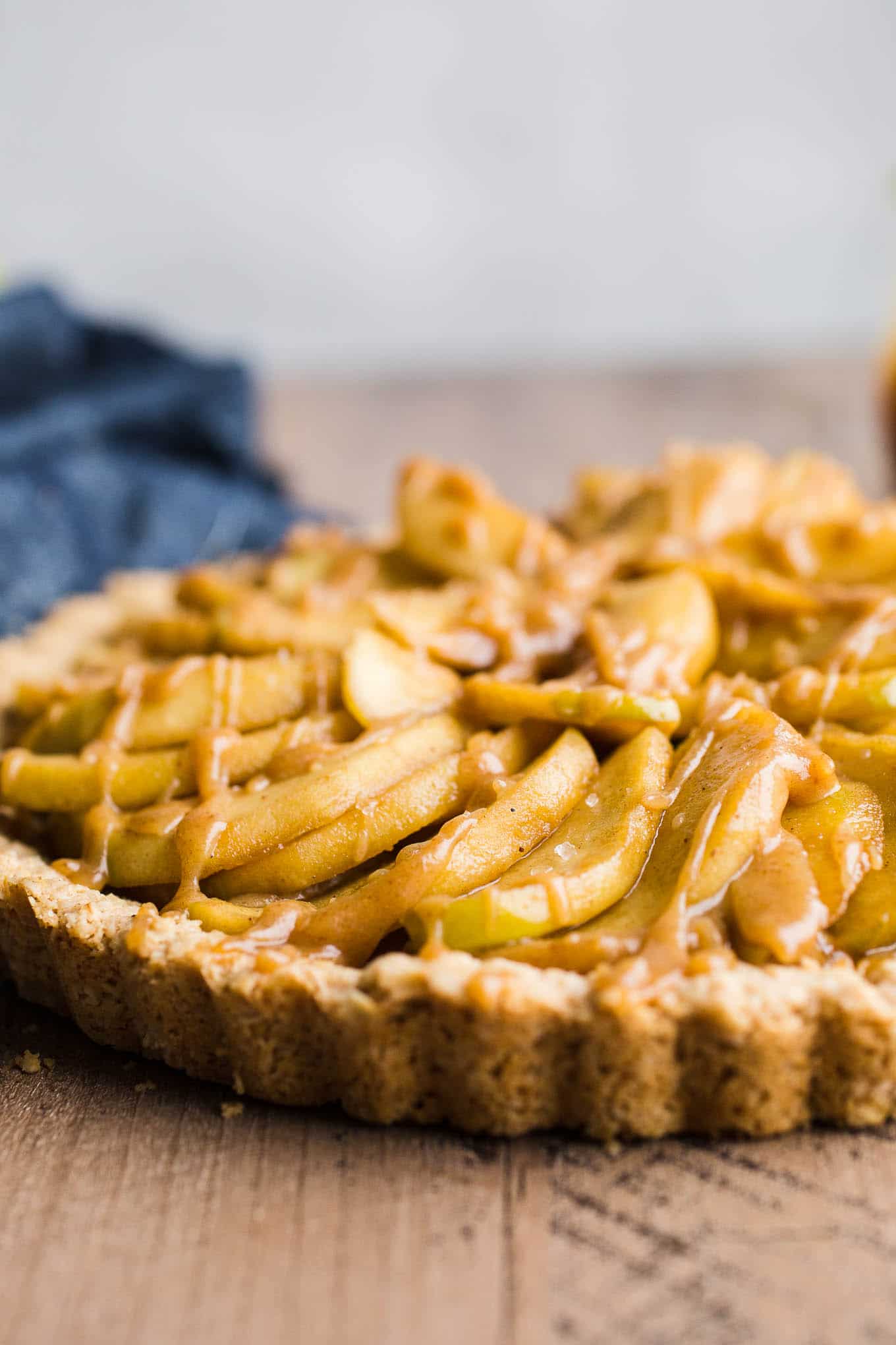 Gluten-Free Apple Tart with Oatmeal Cookie Crust is an easy dessert recipe made with an oat flour crust, a layer of date caramel, and topped with cinnamon apples. Prepare the crust and date caramel ahead of time for easier assembly. Vegan