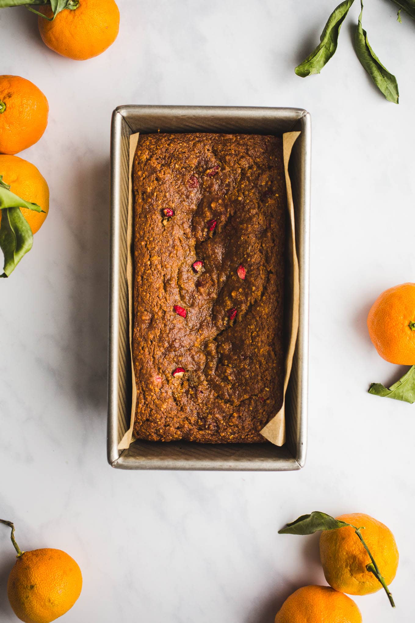 A healthier, moist, Gluten-Free Cranberry Orange Bread with an orange glaze made with almond and oat flours. Vegan. Have it for breakfast or dessert!