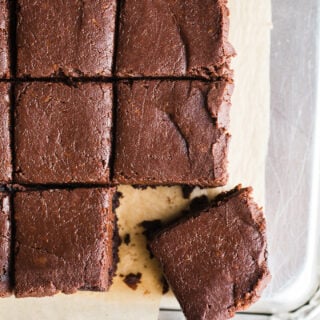 Frosted brownies on a piece of parchment paper.