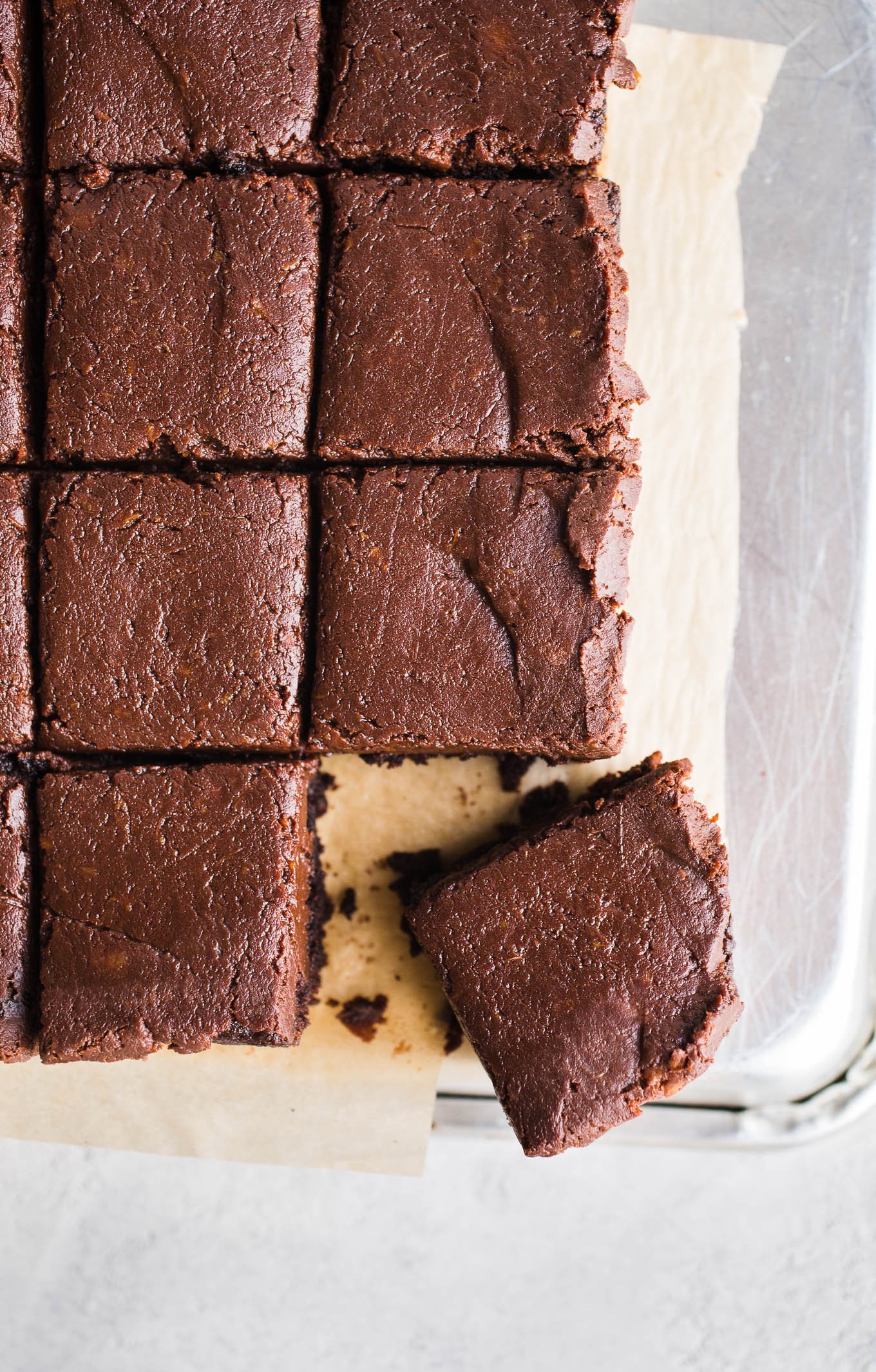 Frosted brownies on a piece of parchment paper.
