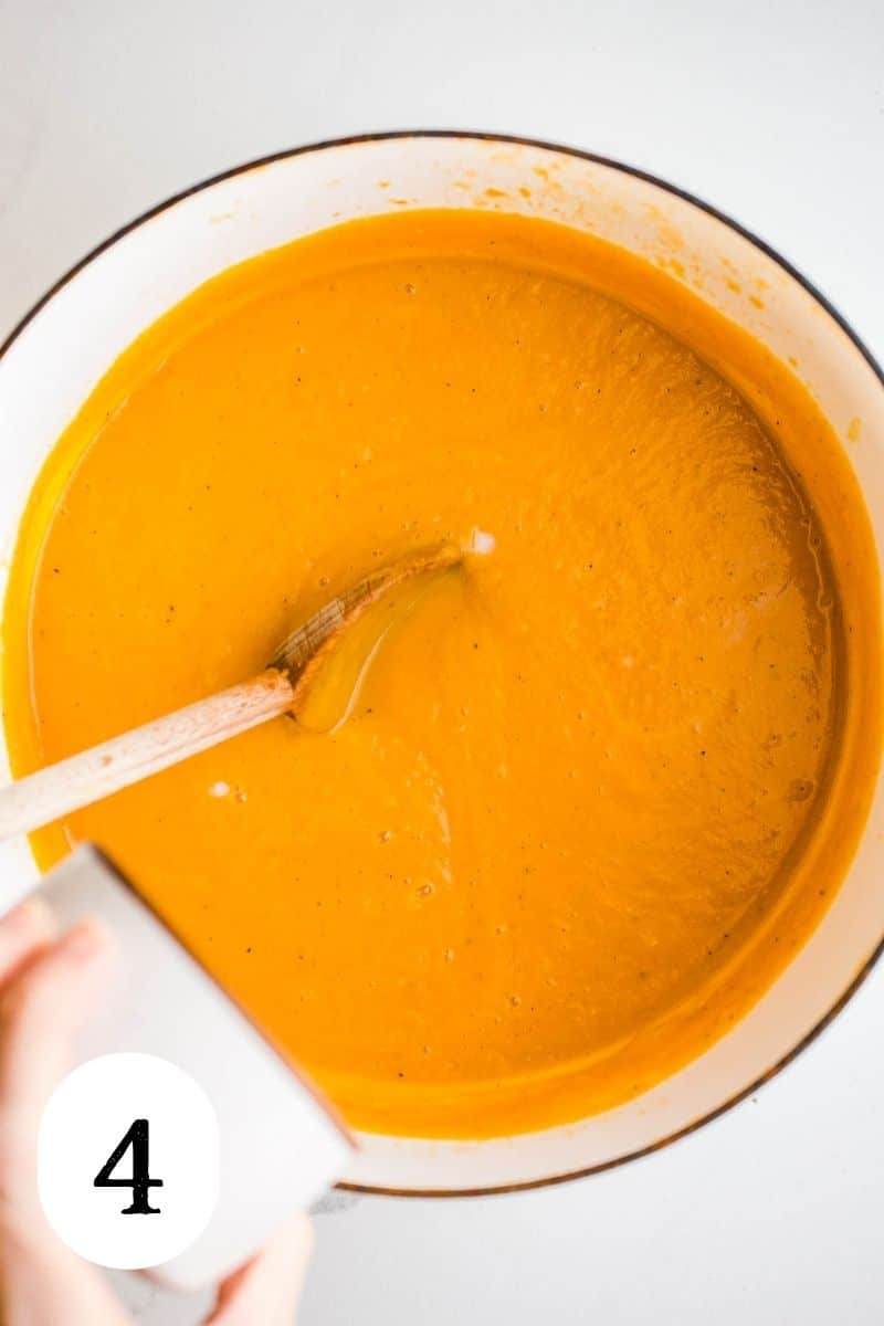 Smooth and creamy sweet potato soup being stirred in a large pot.
