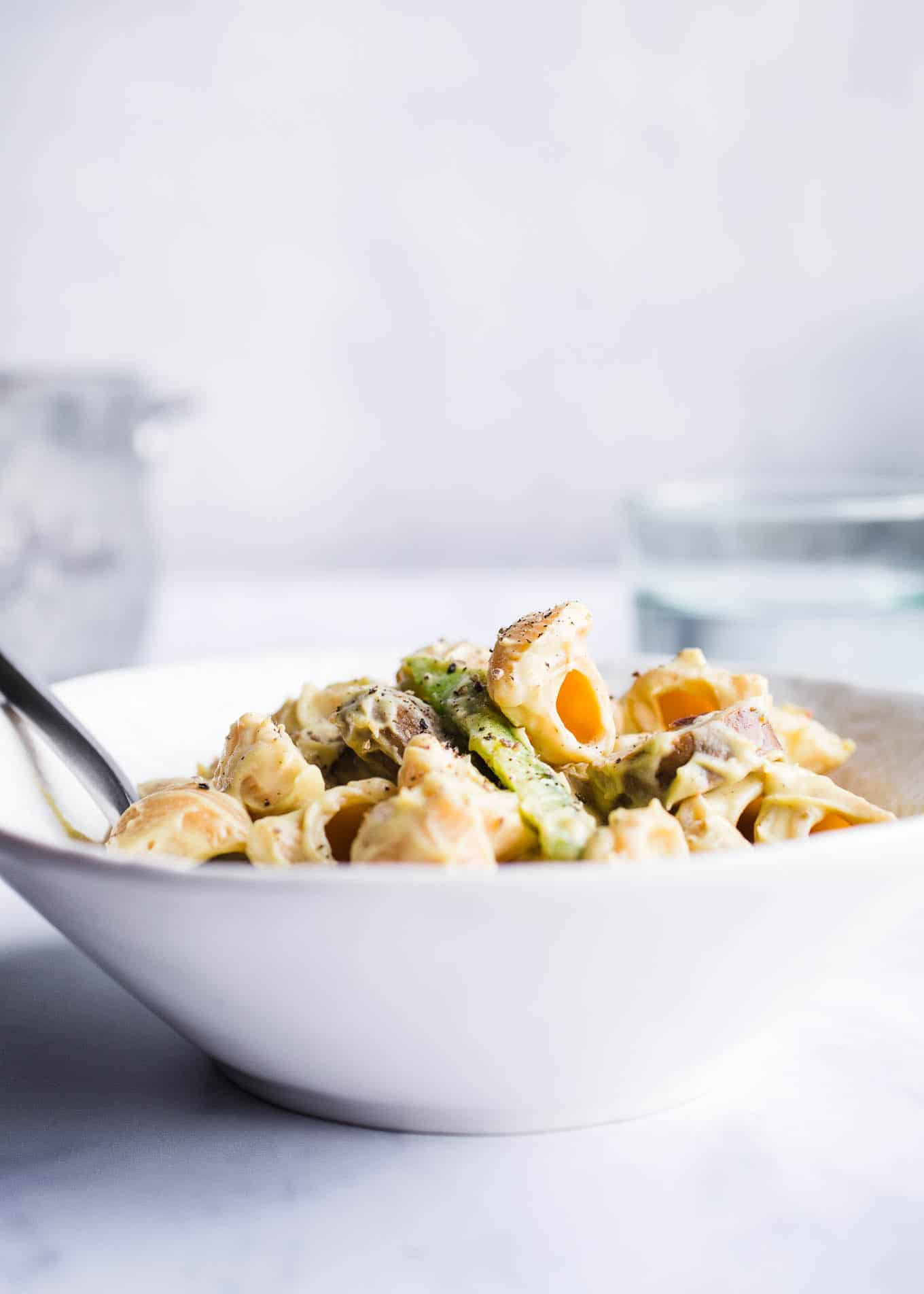 Gluten-free shells and peppers in a white bowl.