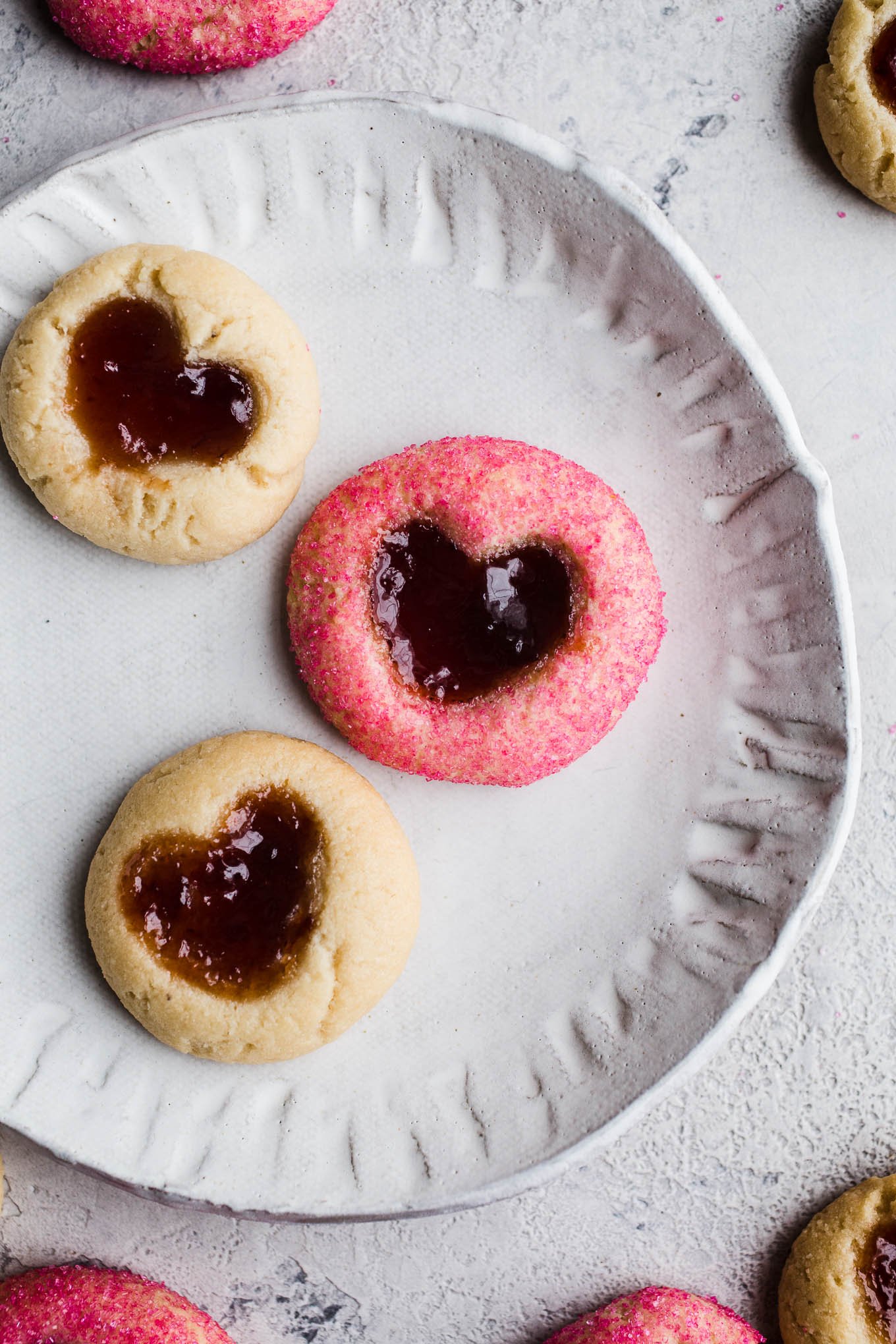 Heart thumbprint cookies on a white plate.