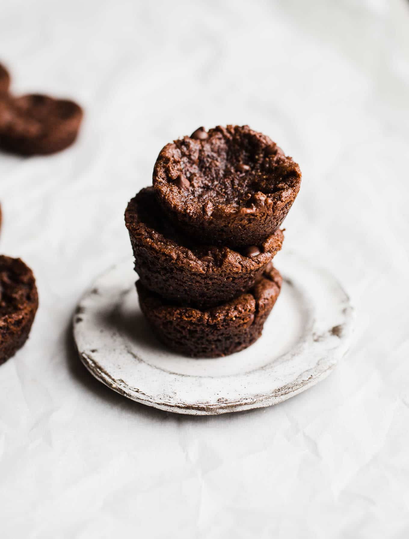 Vegan Gluten-Free Brownie Bites recipe made in a mini muffin pan for individual portions. Topped with an easy dairy-free chocolate ganache and your choice of nuts, sea salt, or sprinkles!