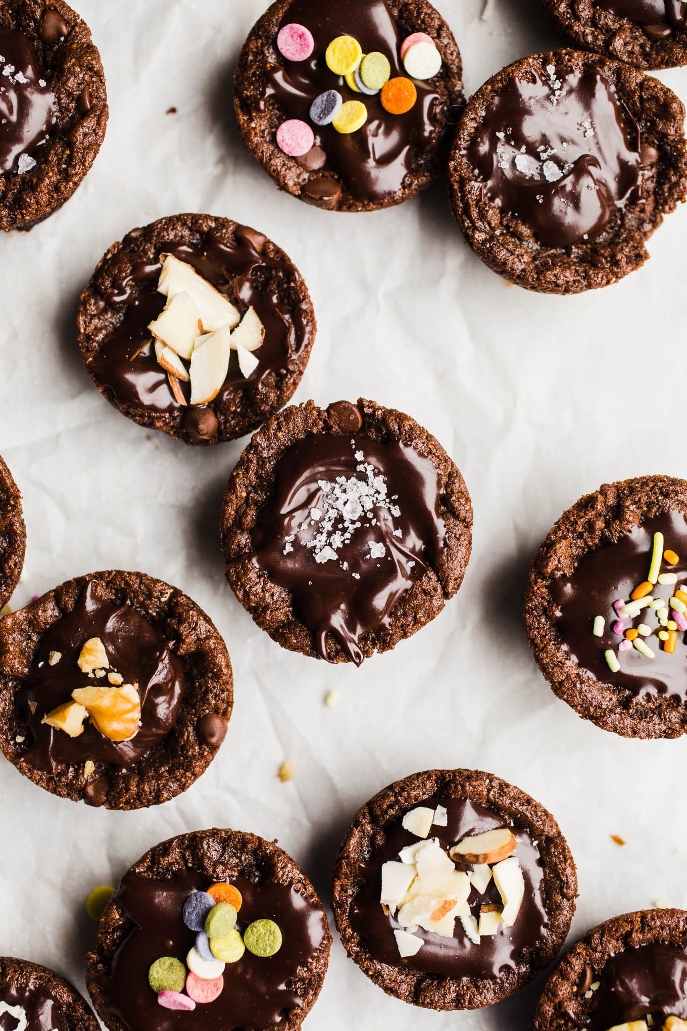 Vegan Gluten-Free Brownie Bites recipe made in a mini muffin pan for individual portions. Topped with an easy dairy-free chocolate ganache and your choice of nuts, sea salt, or sprinkles!