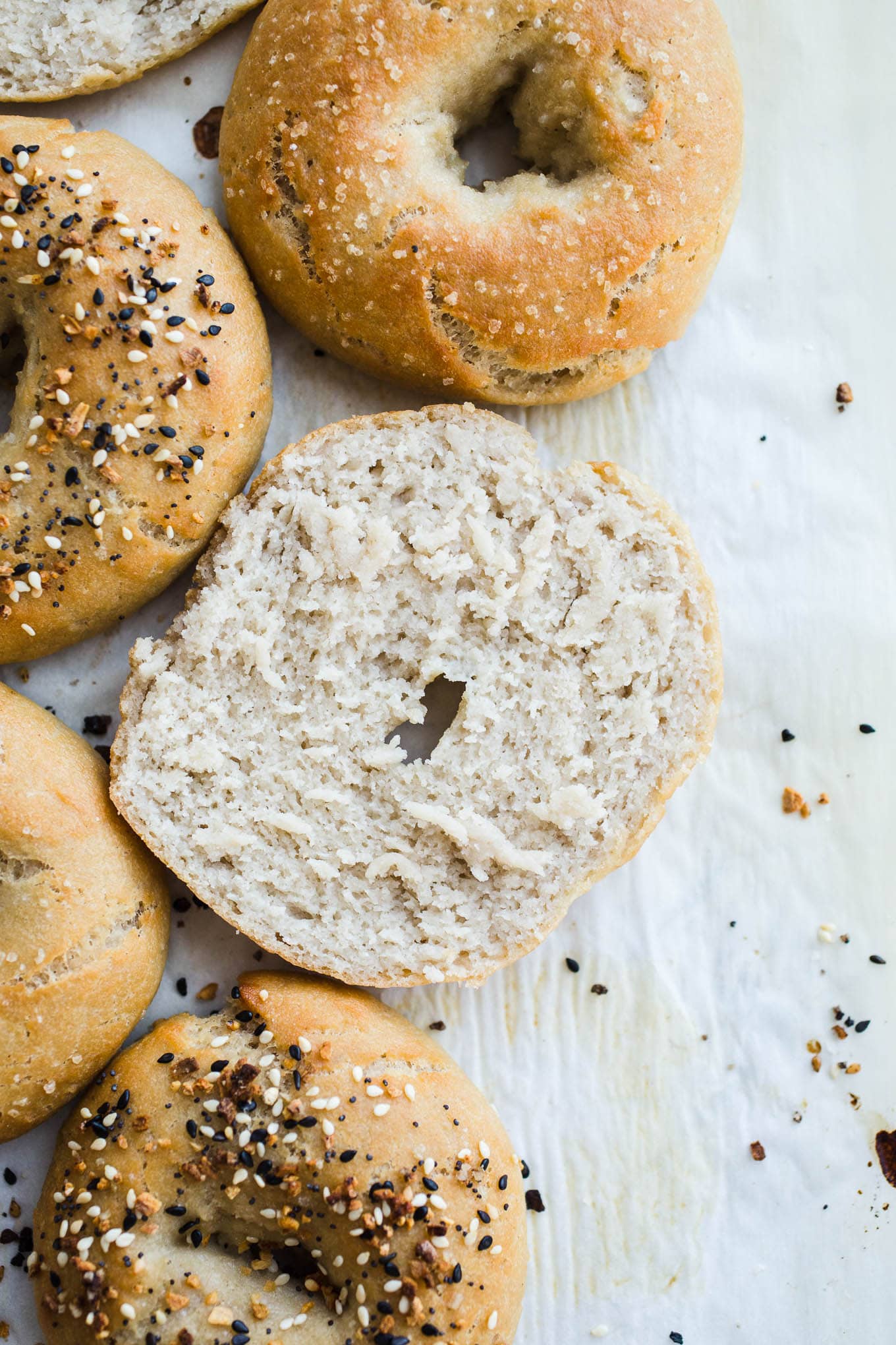 Sliced bagels on parchment paper.