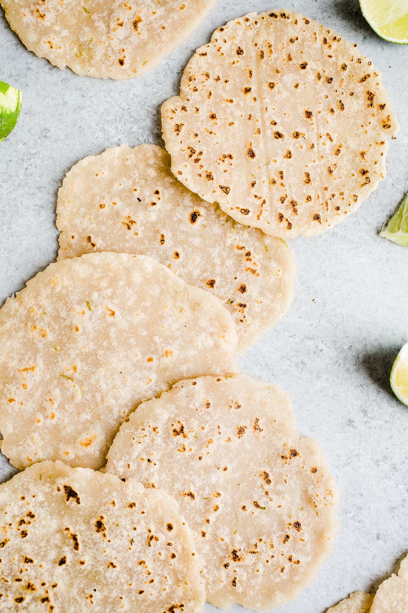 Fresh brown rice tortillas on a blue surface.