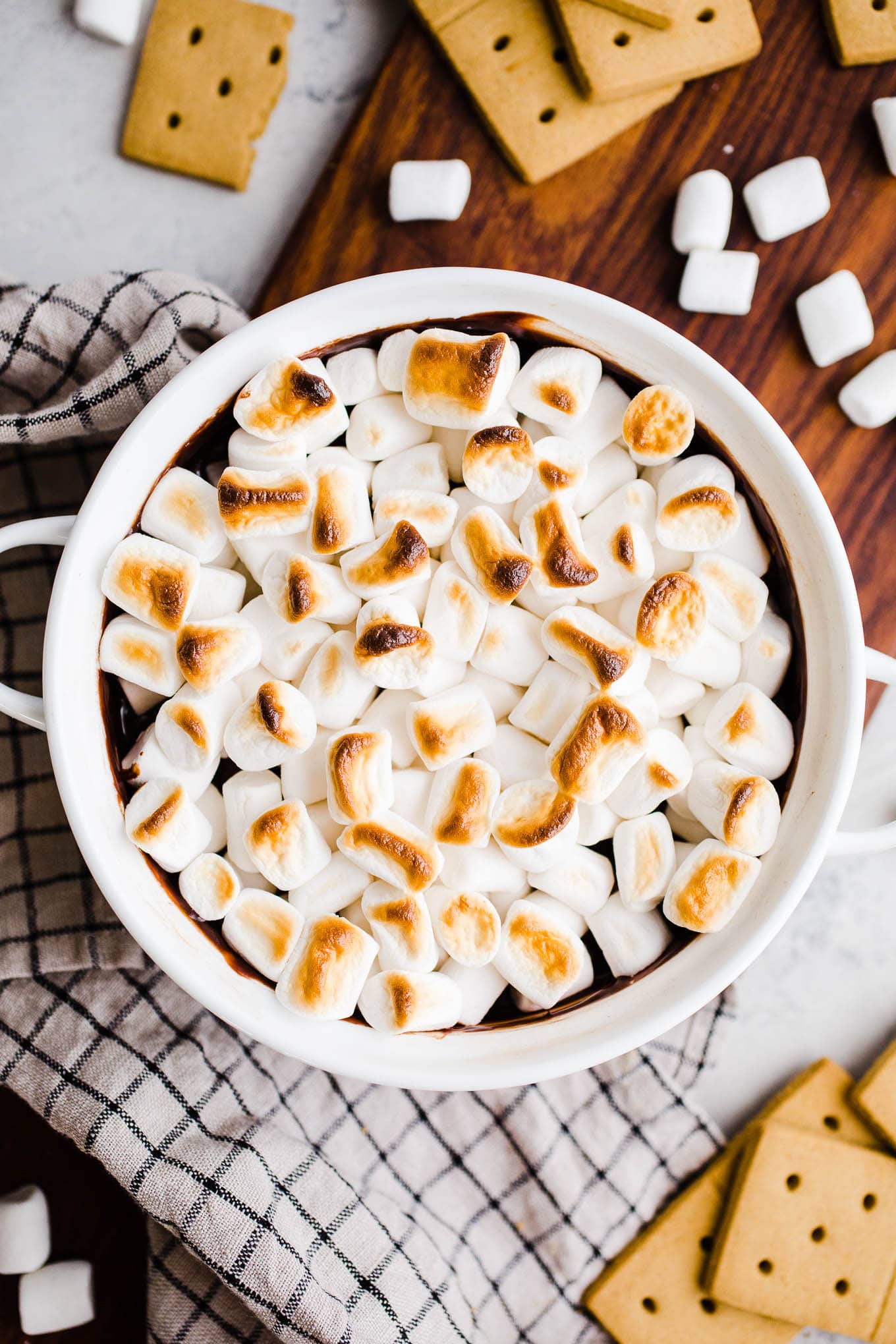 A white baking dish with melted chocolate and toasted marshmallows on top.