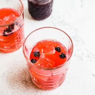 A blackberry cocktail in a rocks glass.