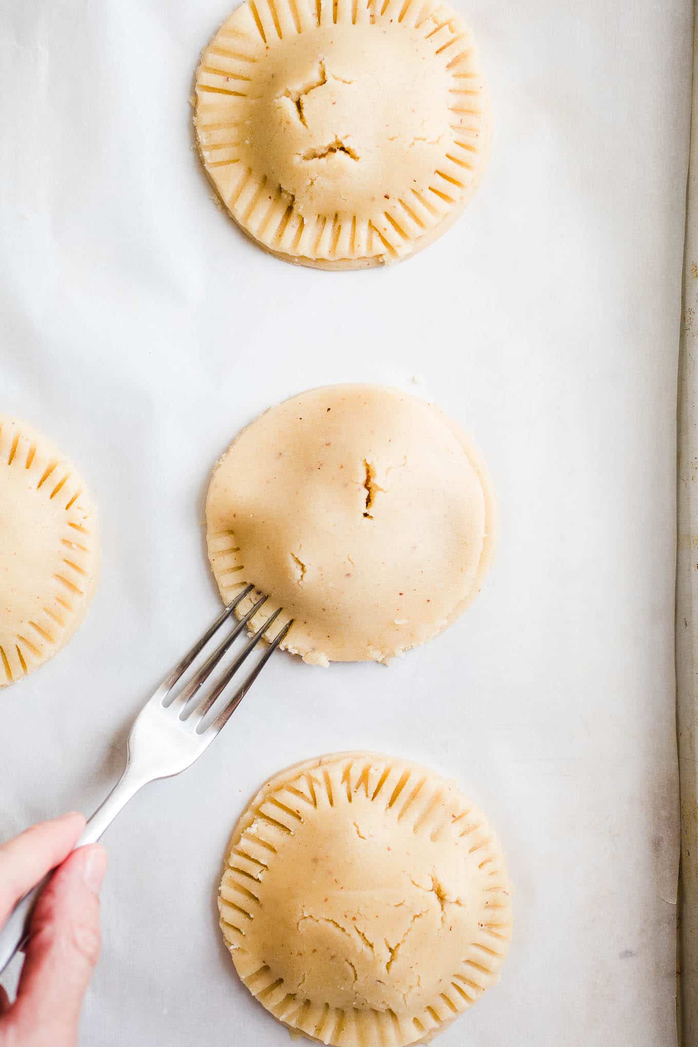 Crimping a pie crust with a fork.