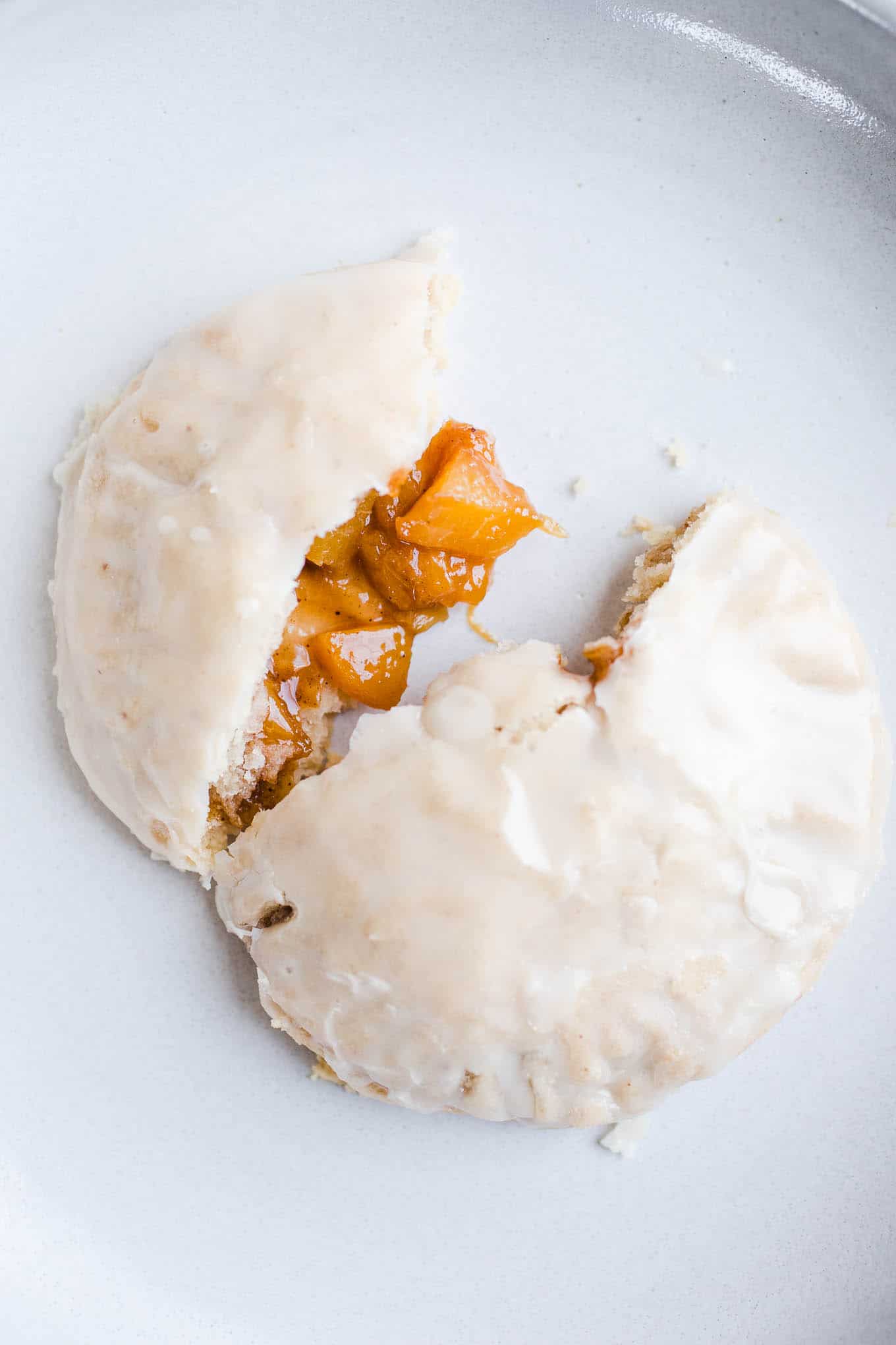 An open peach hand pie on a plate. 