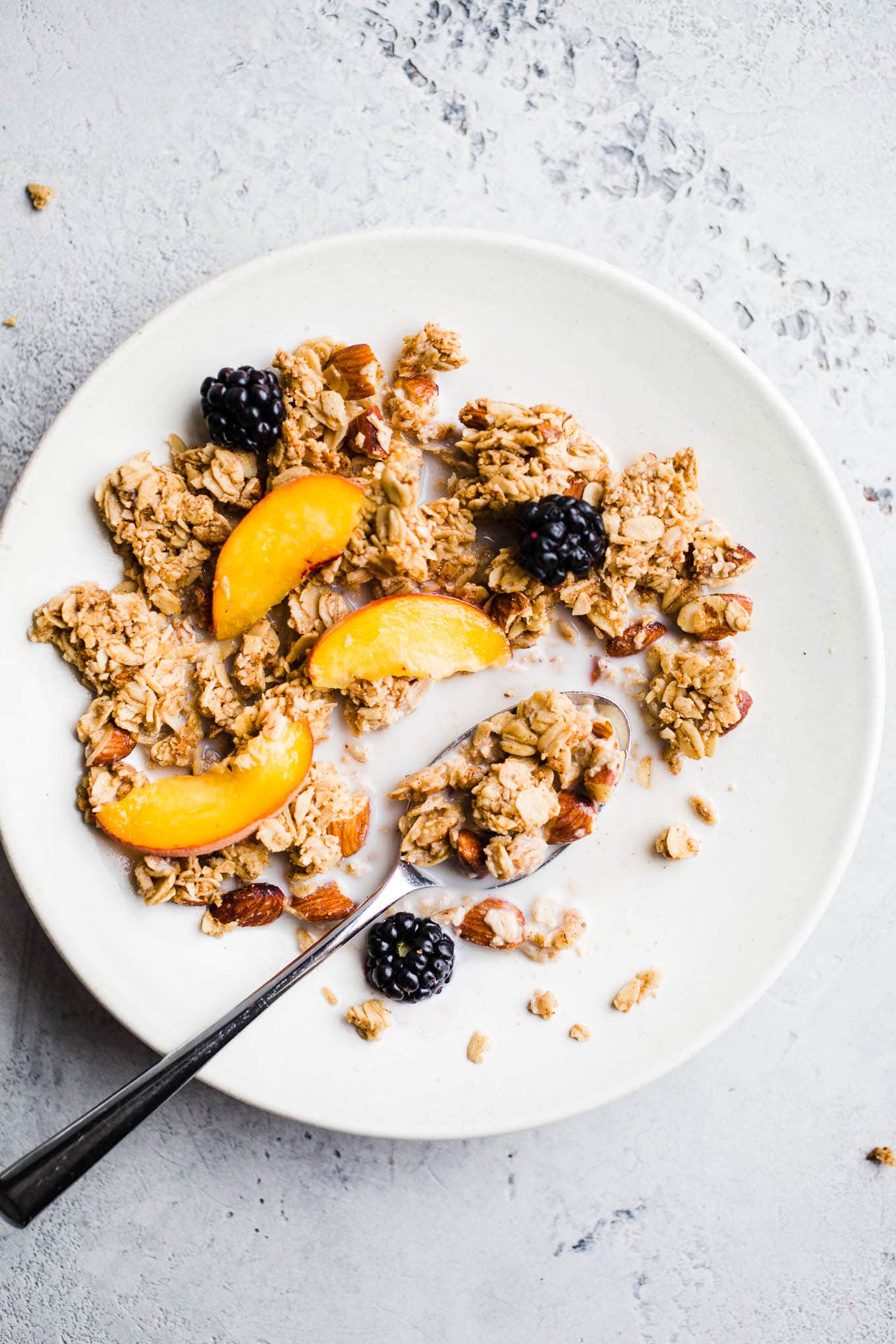 Cereal in a bowl with fresh fruit and milk.