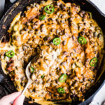 Cheesy black bean dip with jalapenos in a cast iron skillet.