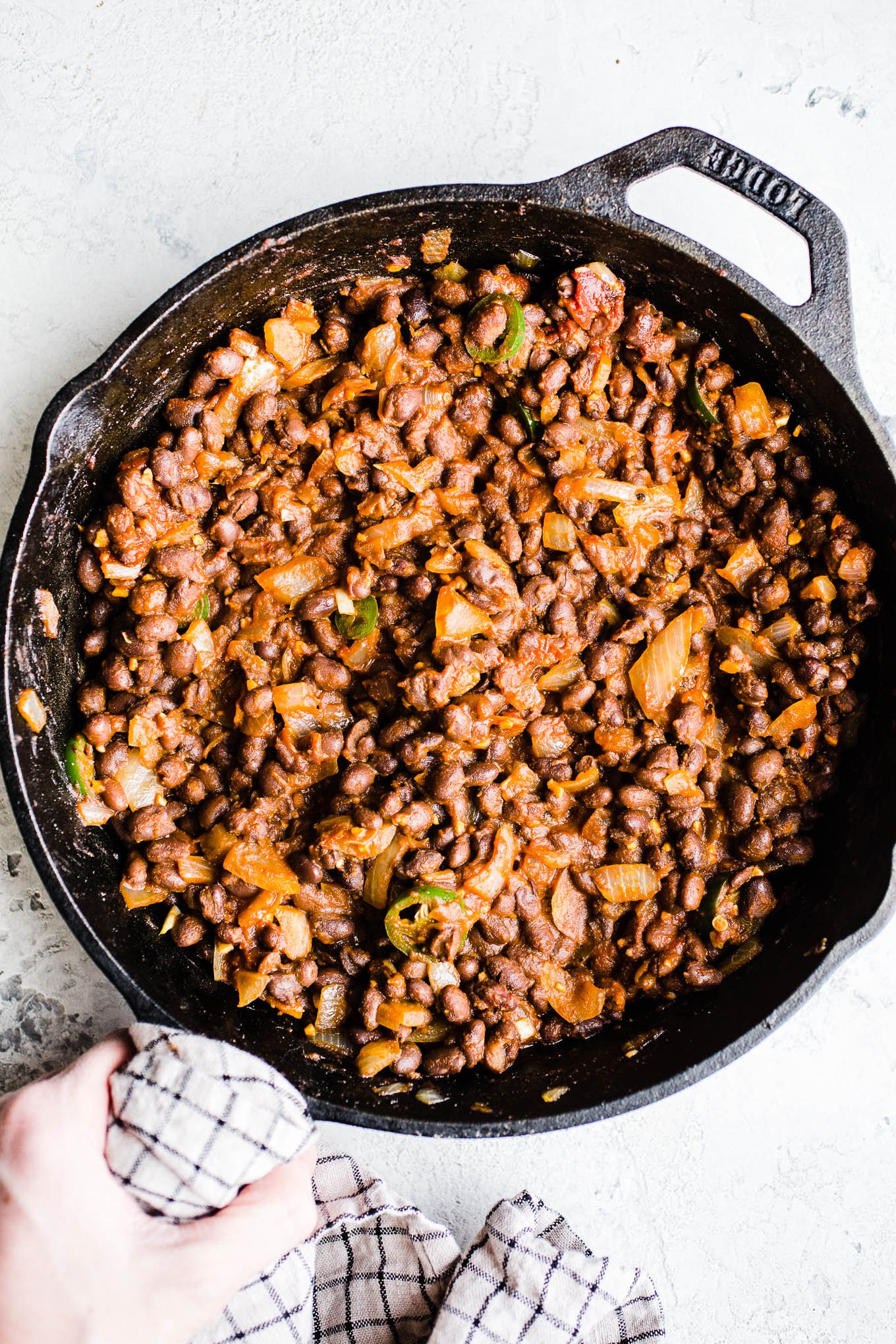 Cooked black beans and onions in a cast iron skillet. 