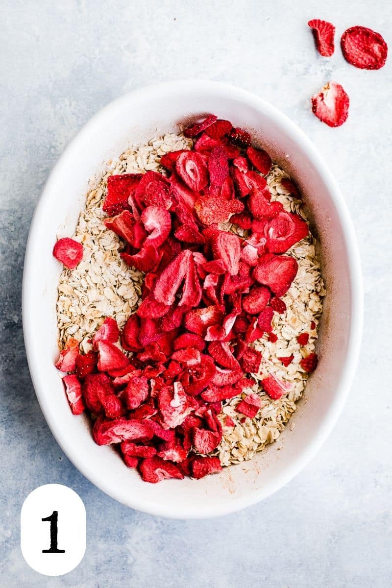 Oats and freeze-dried strawberries in a white dish.
