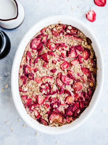 Baked oatmeal with strawberries in a white dish.