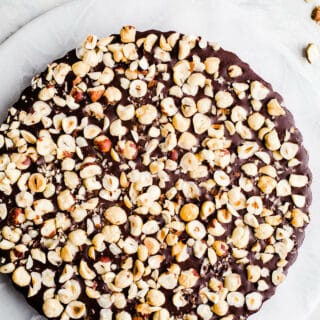 A chocolate tart with hazelnuts on top.