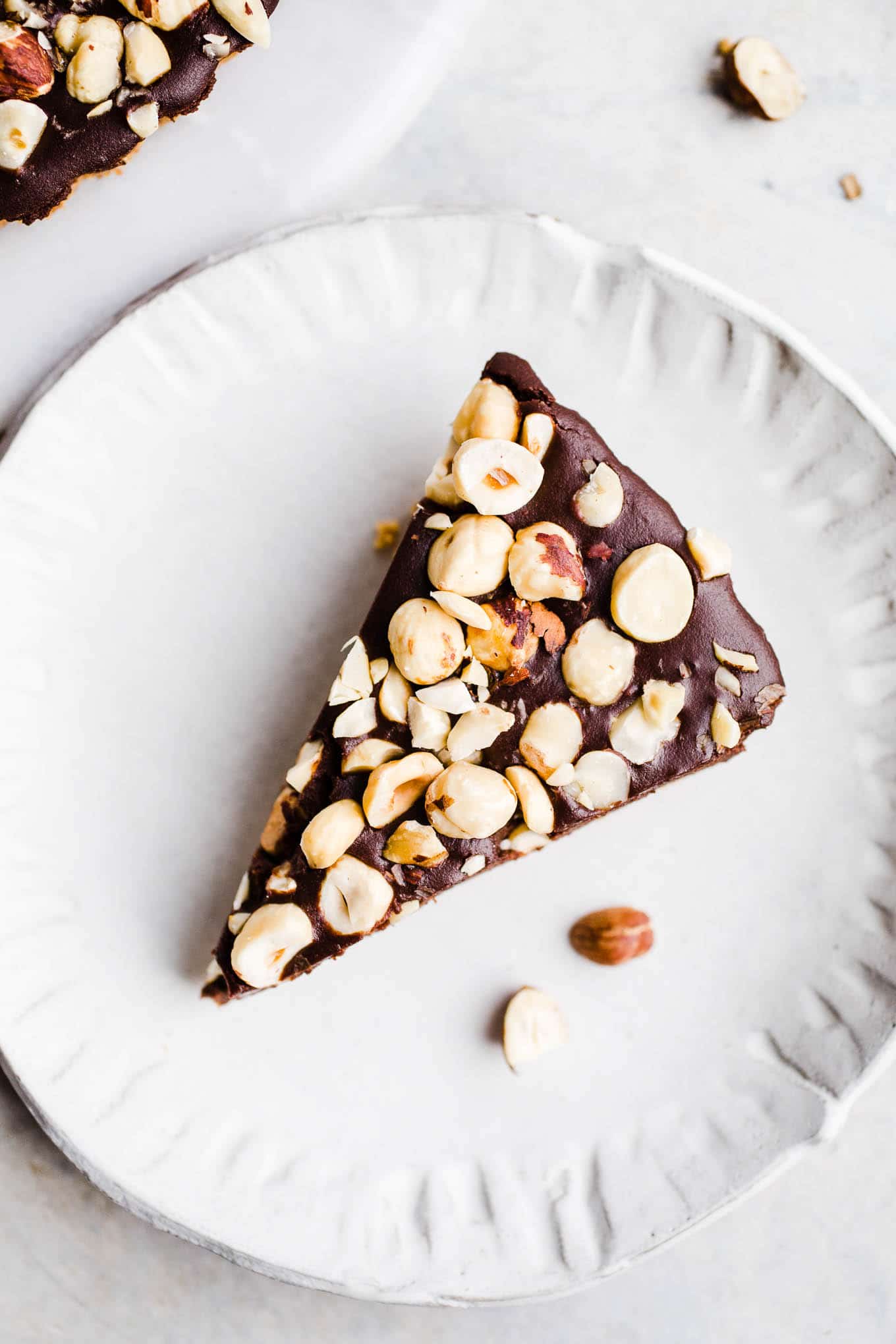 A slice of hazelnut chocolate tart on a white plate. 