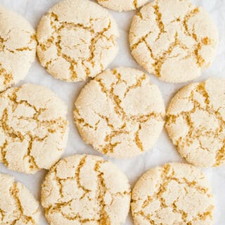 Crackly almond cookies on a piece of parchment paper.
