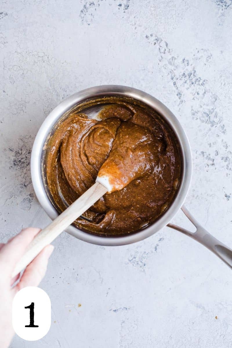Almond butter and maple syrup heating in a saucepan.