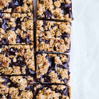 Almond Butter Oat Bars cut into squares on parchment paper.