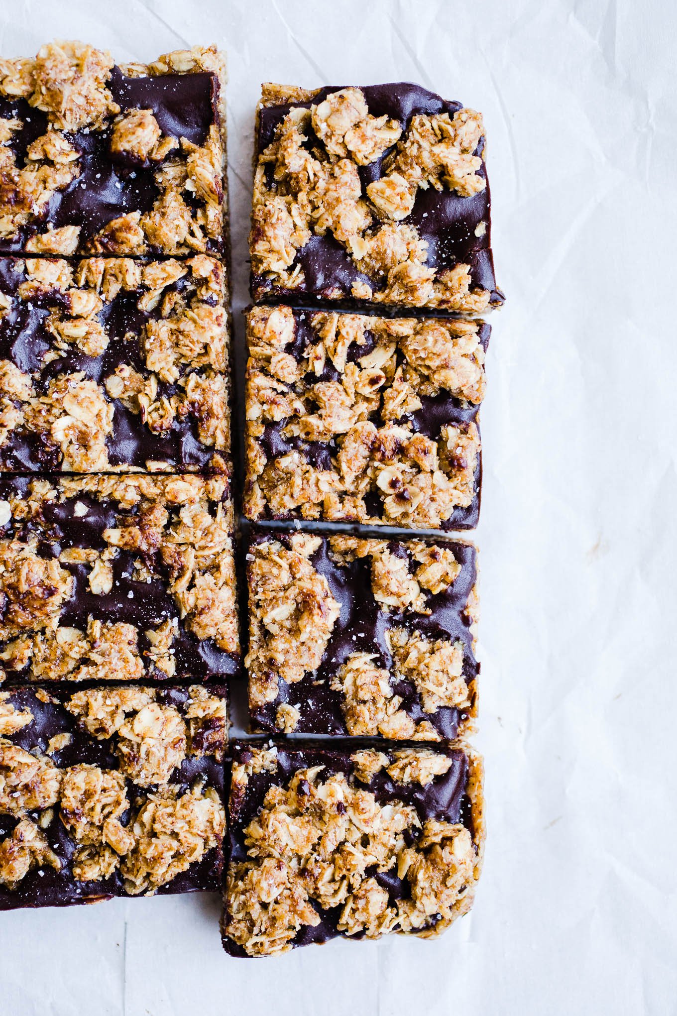 Almond Butter Oat Bars cut into squares on parchment paper.