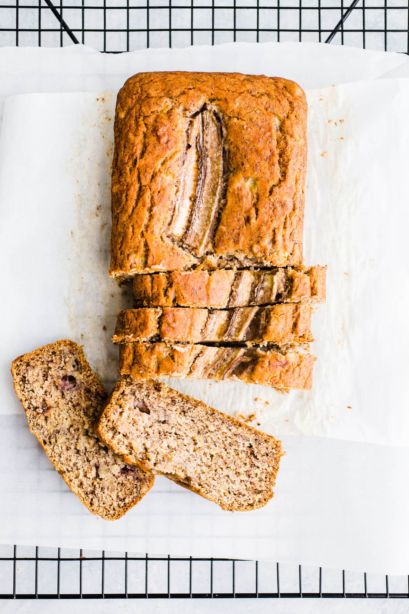 Sliced banana bread on parchment paper.