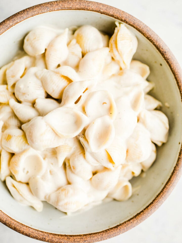 Pasta with alfredo sauce in a rustic bowl.