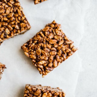 Chocolate squares made with rice cereal on parchment paper.