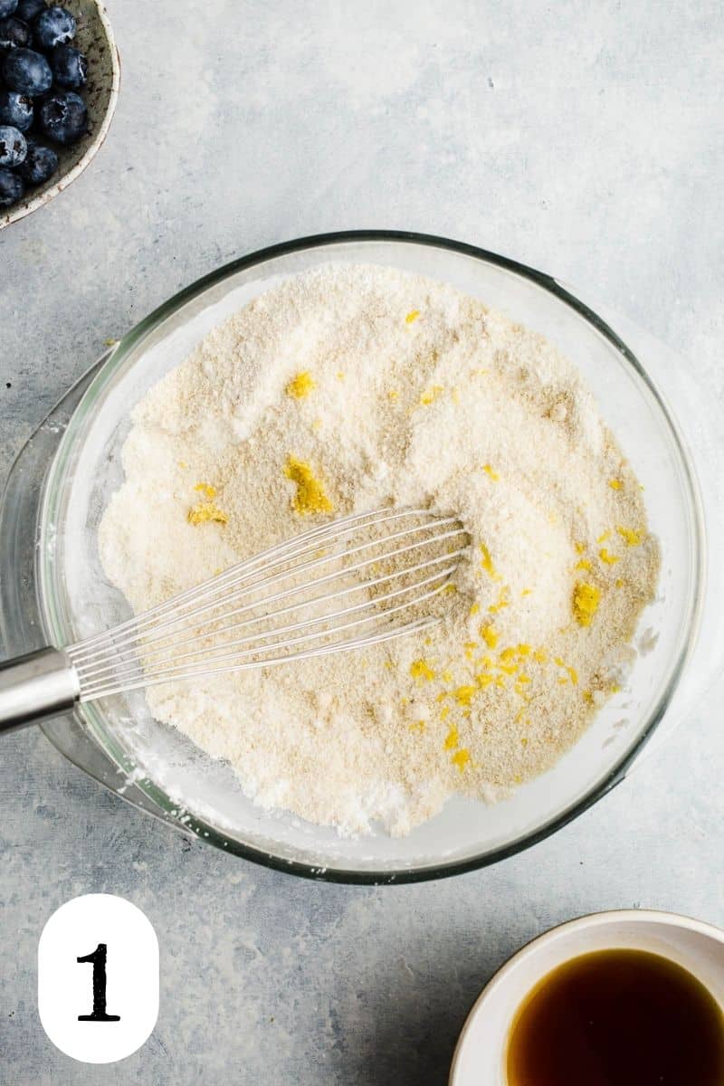 Flour and lemon zest in a glass mixing bowl.