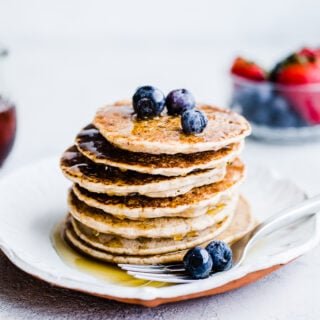 Buckwheat pancakes stacked on a white plate.