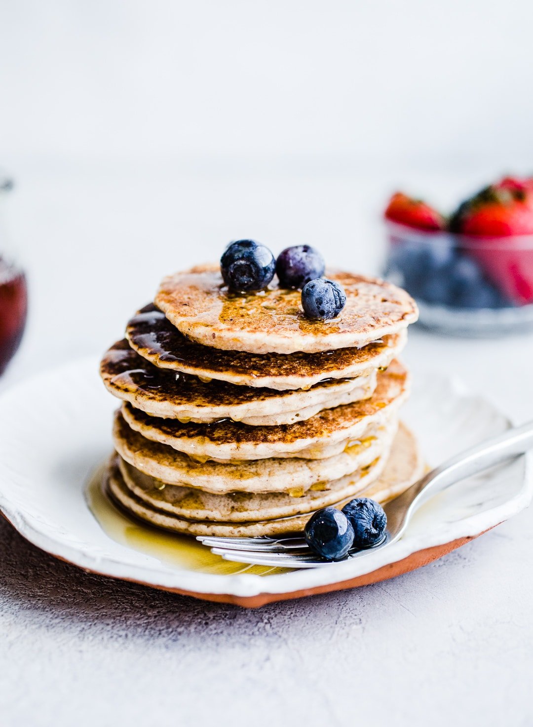 Buckwheat pancakes stacked on a white plate.