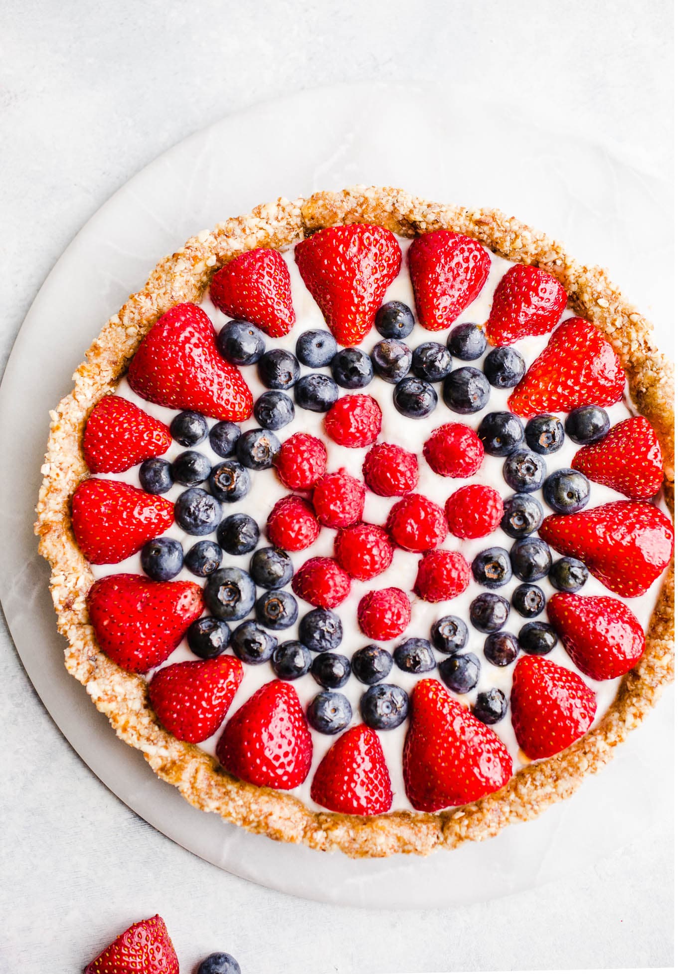 A fruit tart on a marble platter.