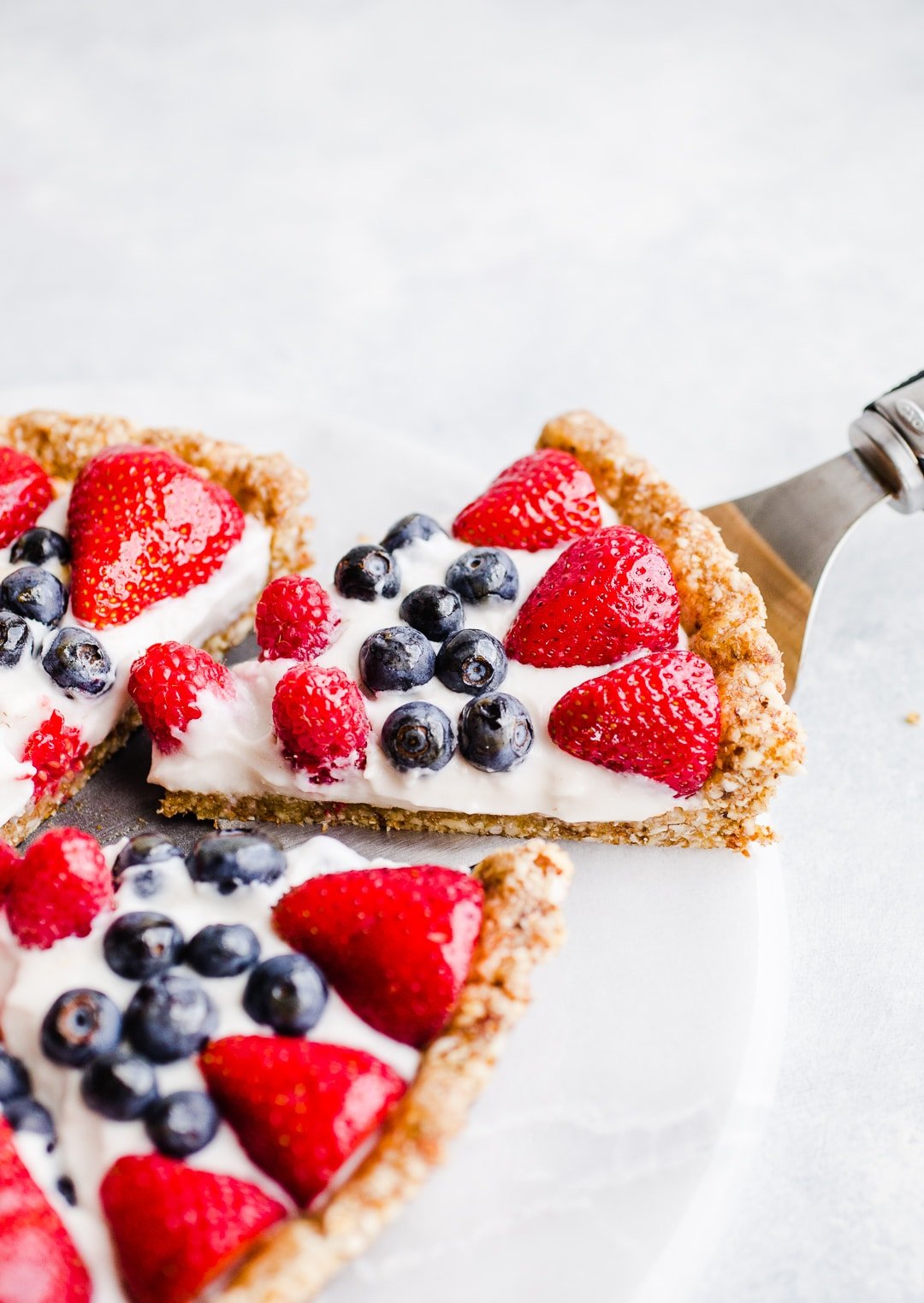 A slice of vanilla tart topped with berries. 