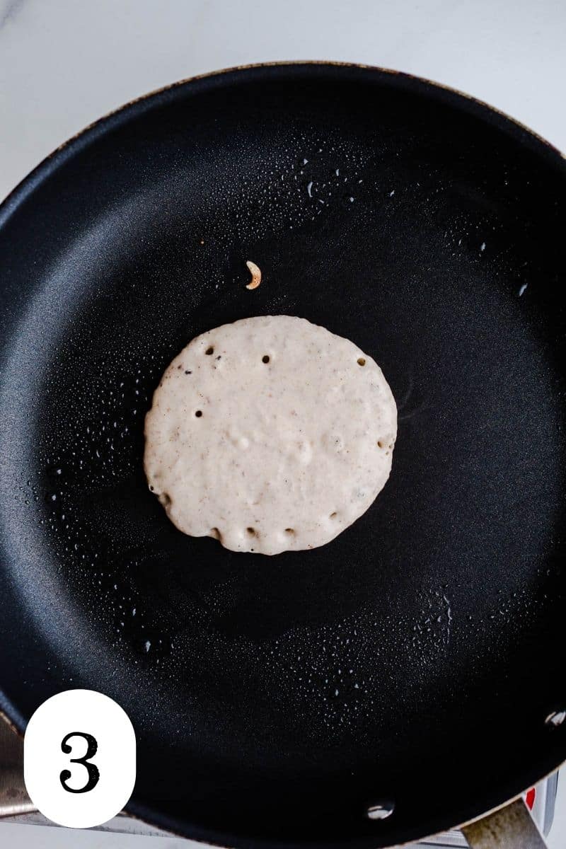 An uncooked pancake on a skillet. 