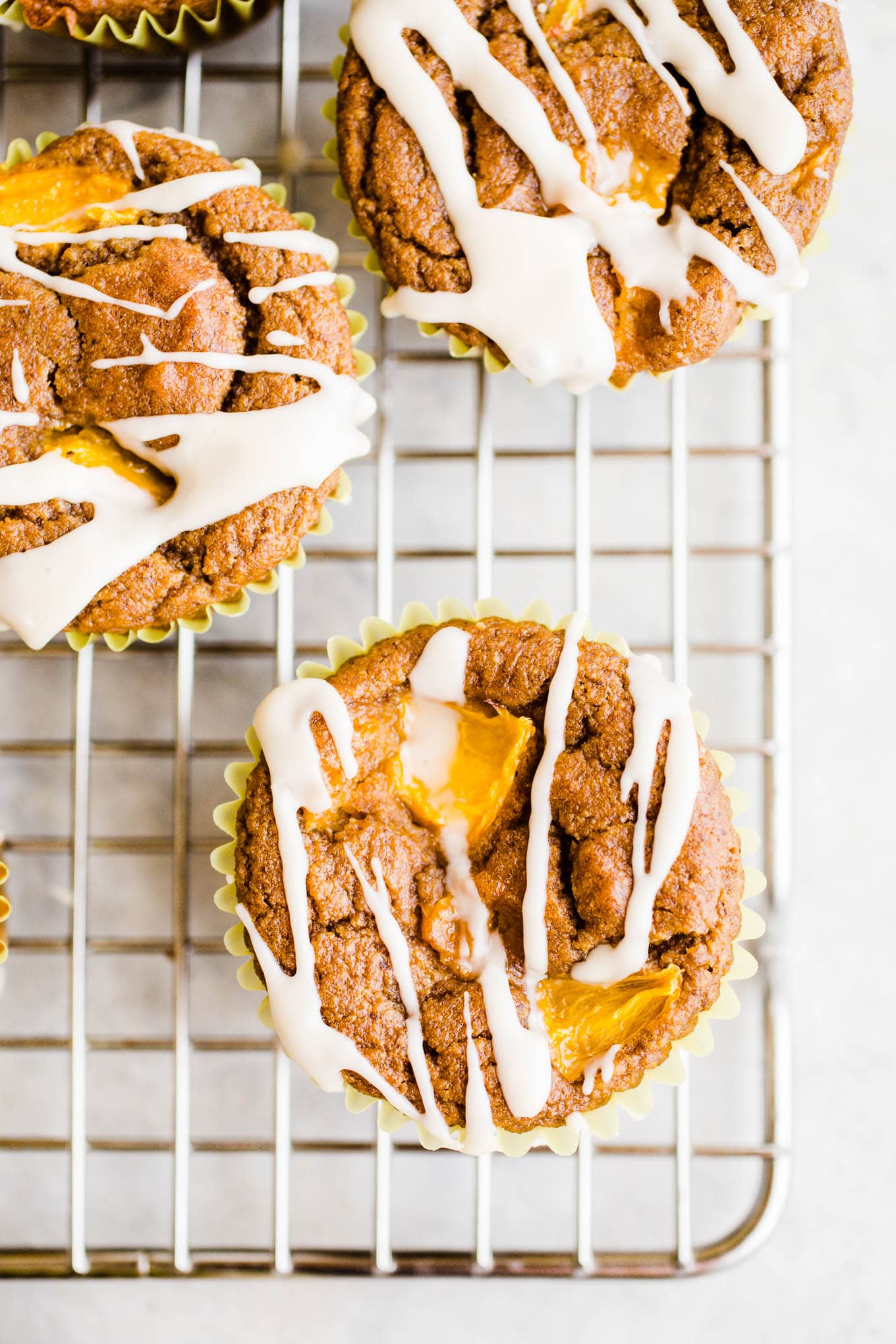 Muffins with icing on a wire rack.