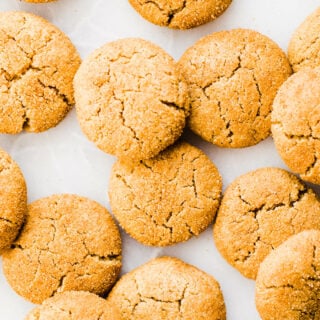 Pumpkin snickerdoodles spread out on a marble surface.