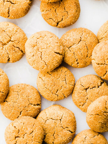Pumpkin snickerdoodles spread out on a marble surface.