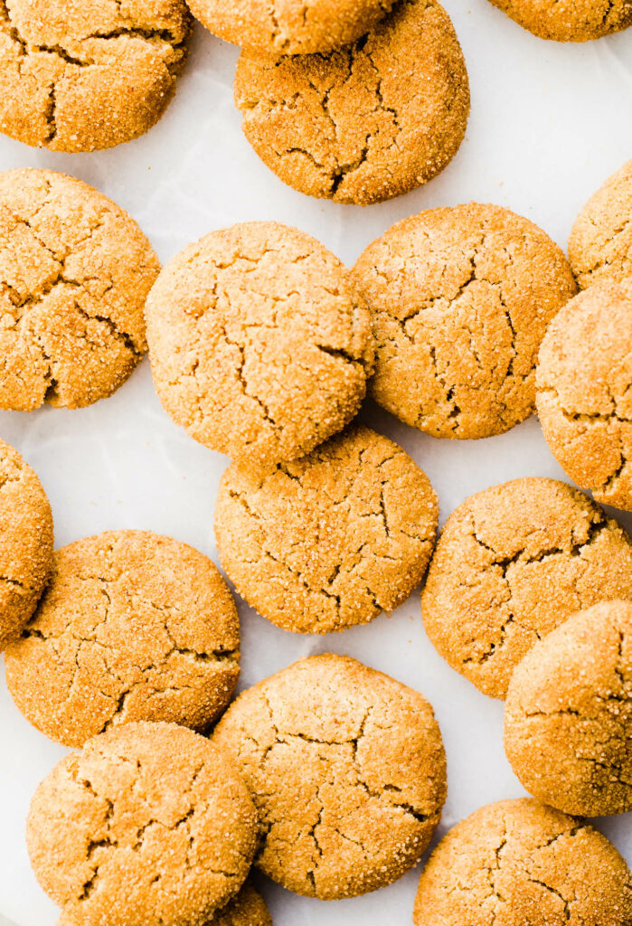 Pumpkin snickerdoodles spread out on a marble surface.